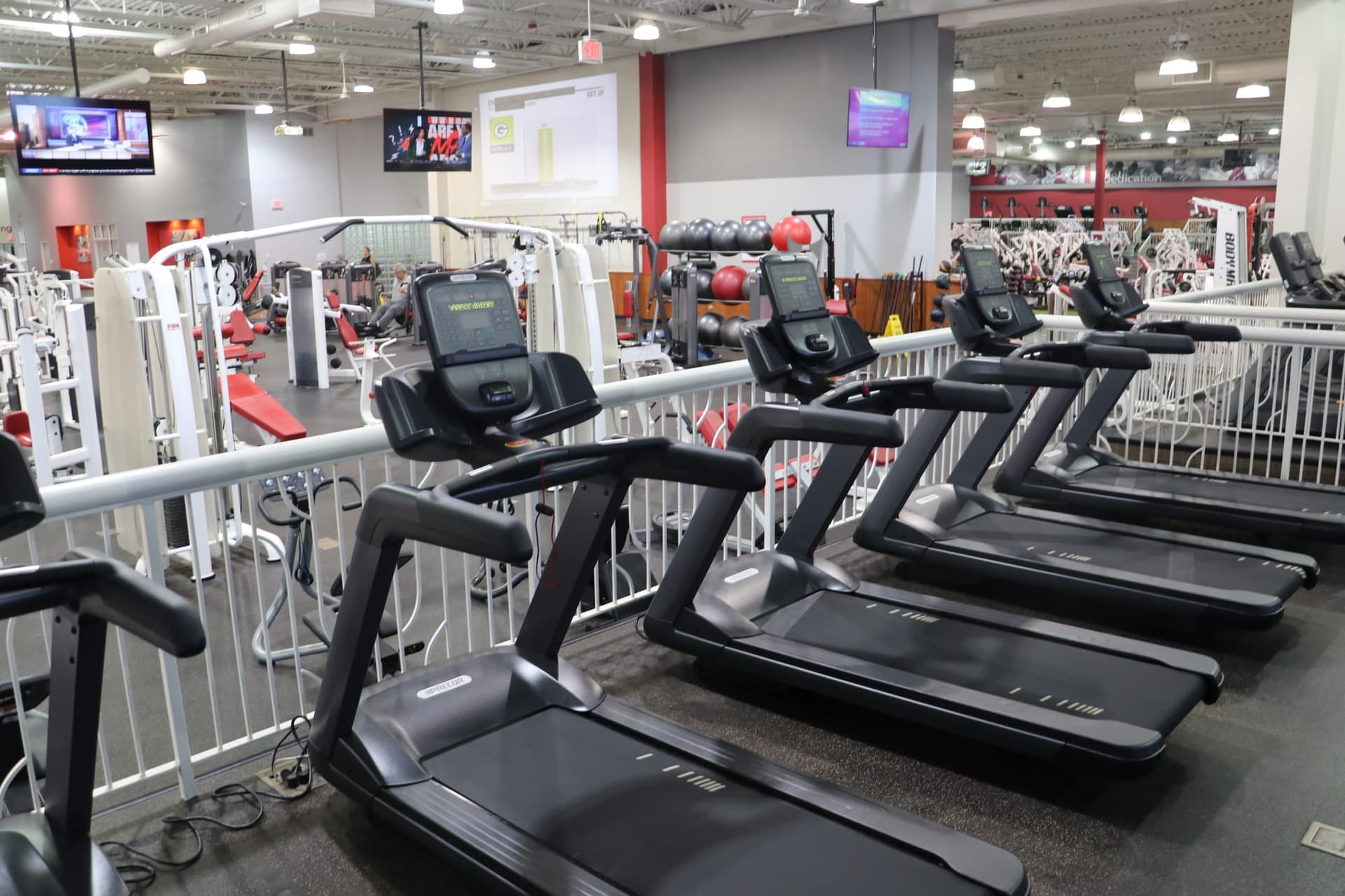 Screens above the cardio floor, fitness club in Teika, 4 × 65-inch — Teika, Riga